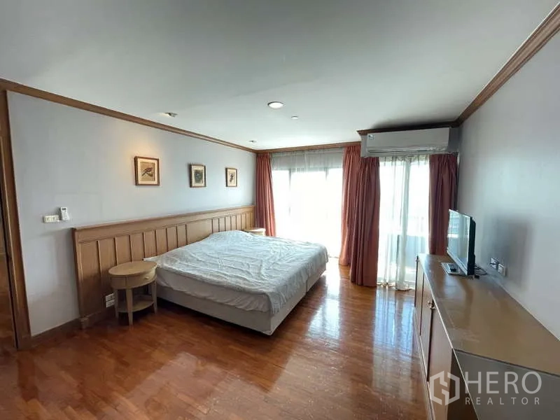 Condominium for rent - Bedroom with wooden headboard, TV console and balcony door with curtains.