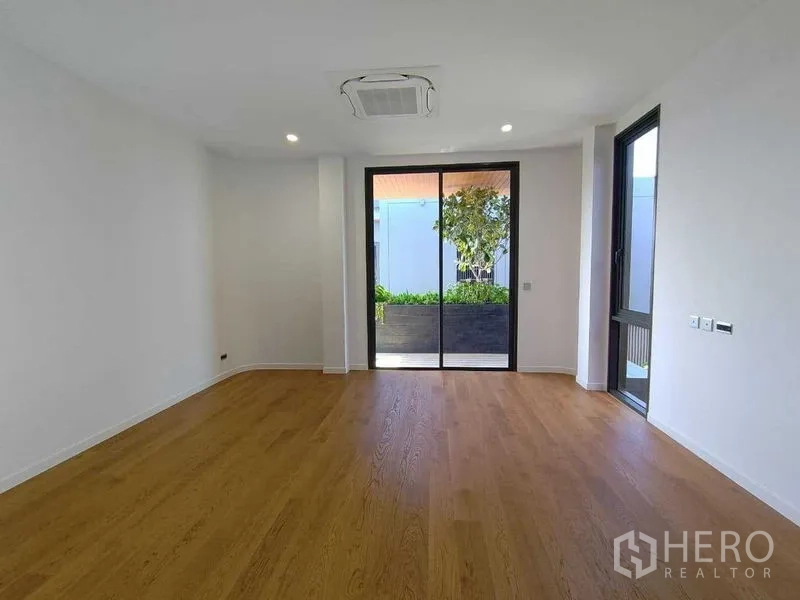 Detached House for rent in Wang Thonglang, Bangkok - Bedroom opening to a balcony planter with greenery.