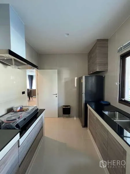 Detached House for rent in Bang Kapi, Bangkok - Fully fitted kitchen with wood cabinets, black countertops and window.
