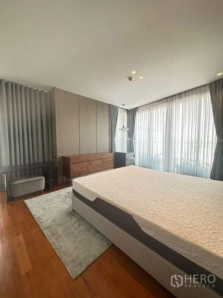 คอนโด ขายในWatthana, Bangkok - ห้องนอนมาสเตอร์มุมอาคาร หน้าต่างบานใหญ่ ตู้เสื้อผ้าบิวท์อิน และเตียงคิงไซส์