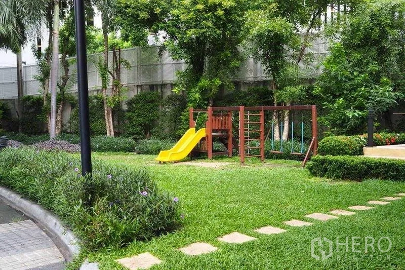 公寓 出租在Watthana, Bangkok - 绿意花园内的儿童游乐场和黄色滑梯