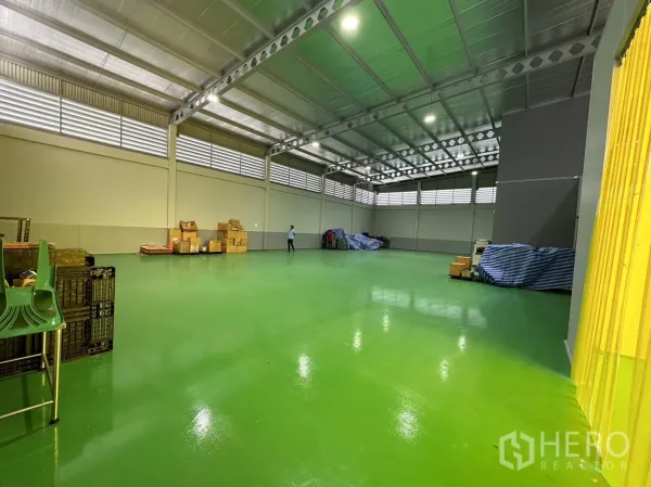 工厂 出售在Lam Luk Ka, Pathum Thani - 高挑厂房大厅，绿色环氧地坪与通风百叶。