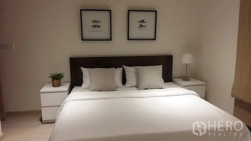 公寓 出租在Watthana, Bangkok - 主卧配大床、床头柜与柔和灯光。