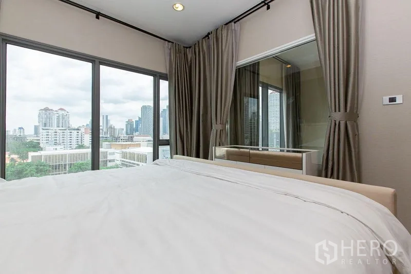公寓 出租在Khlong Toei, Bangkok - 卧室转角展示大面积窗户与无遮挡的曼谷城景。
