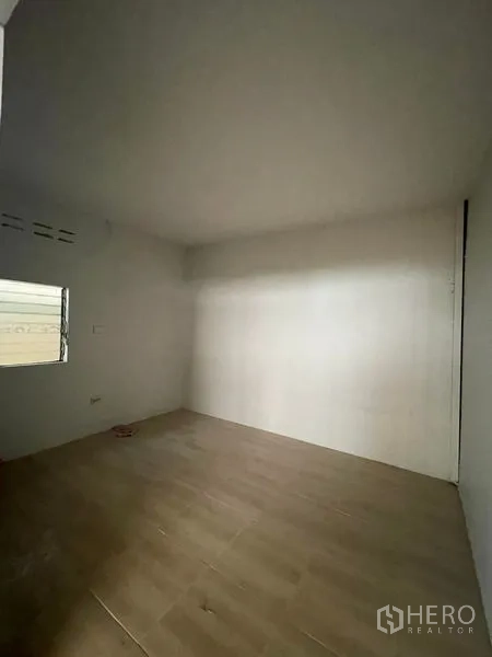 Factory for rent in Lat Lum Kaeo, Pathum Thani - Empty white room with a small window and wood-look flooring.