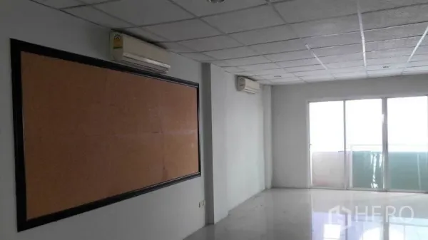 办公空间 出租在Bueng Kum, Bangkok - 采光充足的办公室，软木公告板与通往阳台的推拉玻璃门。