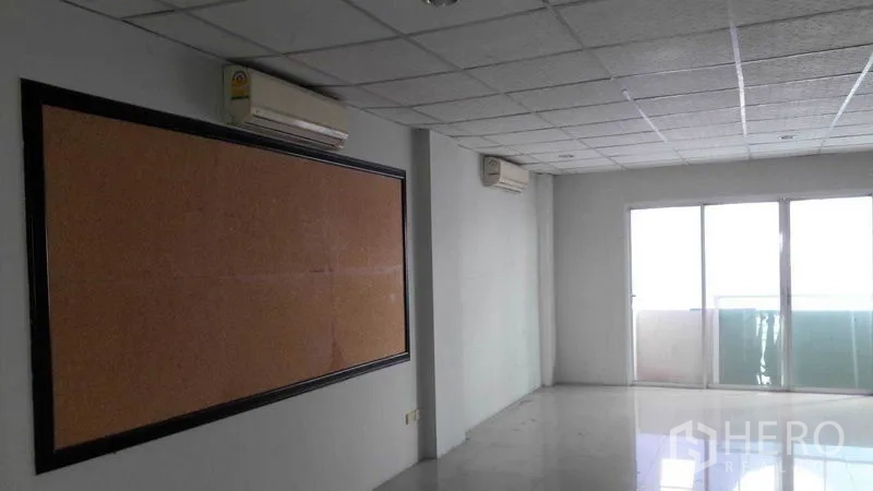 办公空间 出租在Bueng Kum, Bangkok - 采光充足的办公室，软木公告板与通往阳台的推拉玻璃门。