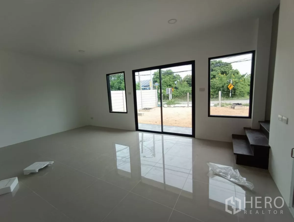 Factory for rent or sale in Bang Yai, Nonthaburi - Bright ground-floor office with glossy tiled floor, glass sliding door, and stairway.