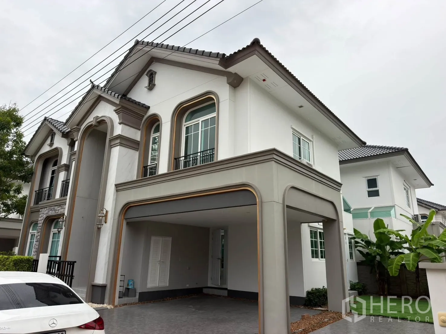 Detached House for rent or sale in Bang Phli, Samut Prakan - Two-storey house exterior with arched windows and a covered carport.