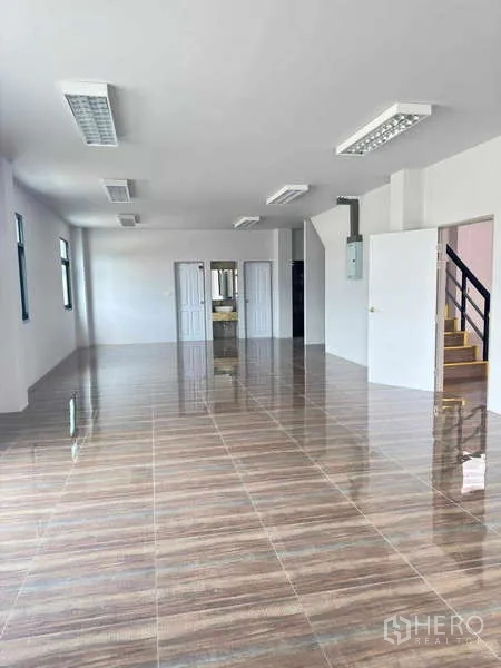 货栈 出租在Mueang Rayong, Rayong - 开放式办公室空间，亮面地砖、照明、门与楼梯连通。