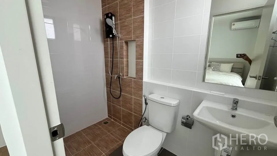 Townhouse for rent or sale in Bang Phli, Samut Prakan - Bathroom with walk‑in shower, water heater, toilet, sink and wall mirror.
