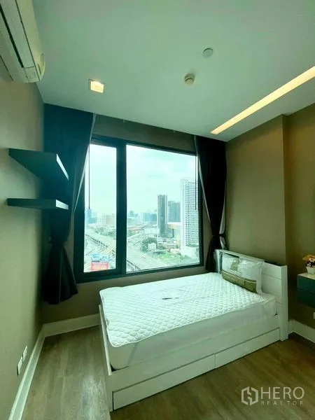 Condominium for rent in Bangkok - Bright bedroom with large window, double bed, wood flooring and expansive city skyline view.