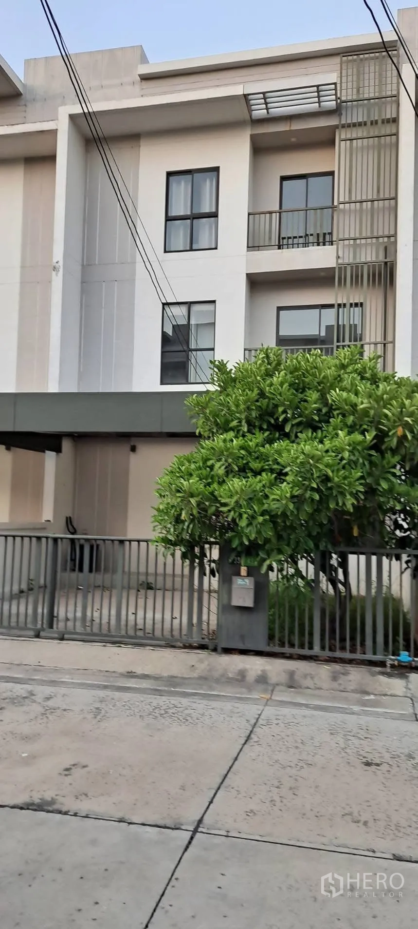 ทาวน์เฮาส์ for rent in Saphan Sung, Bangkok - ด้านหน้าทาวน์เฮ้าส์สไตล์โมเดิร์น 3 ชั้น มีรั้ว ประตู และที่จอดรถในร่มพร้อมระเบียง