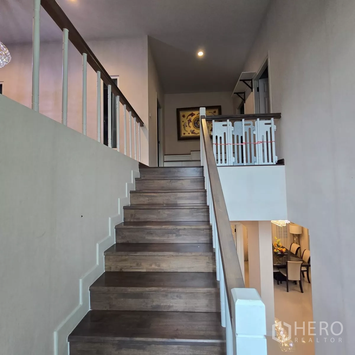 Detached House for rent in Mueang Pathum Thani, Pathum Thani - Wood staircase with white balustrade leading to the upper floor landing.