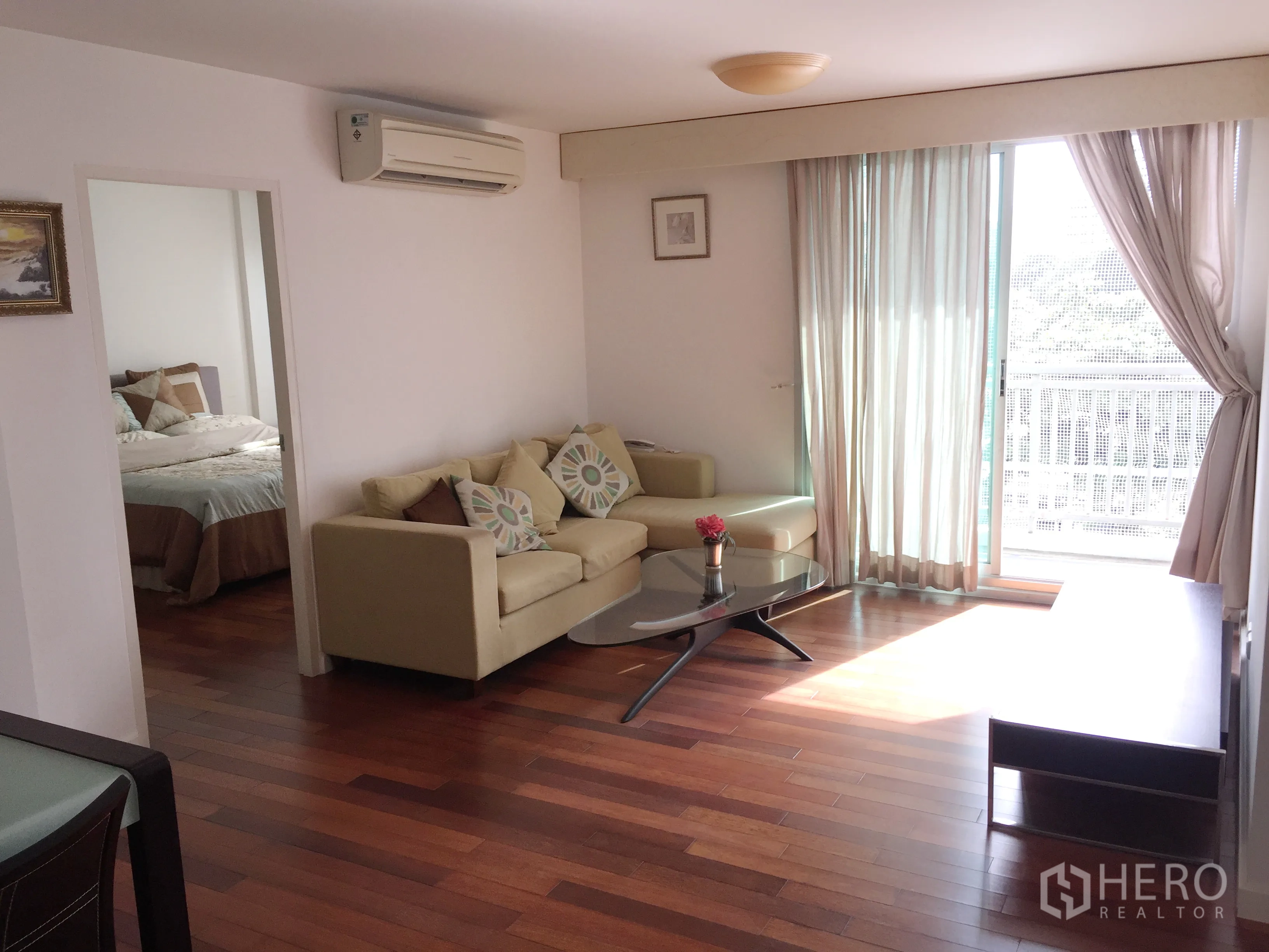 คอนโด ให้เช่าในWatthana, Bangkok - ห้องนั่งเล่นสว่างด้วยประตูกระจกบานเลื่อนสู่ระเบียง โซฟาและโต๊ะกลาง