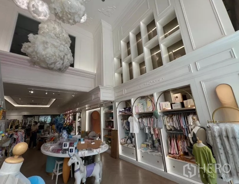 Retail Space for rent in Watthana, Bangkok - Built-in illuminated arch shelves and tall feature wall in a high-ceiling showroom.