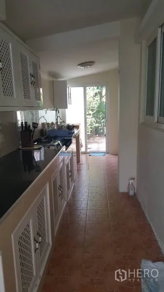 独立式住宅 出售在Mueang Nonthaburi, Nonthaburi - 独立泰式厨房与杂物区，白色橱柜并有通往后花园的门