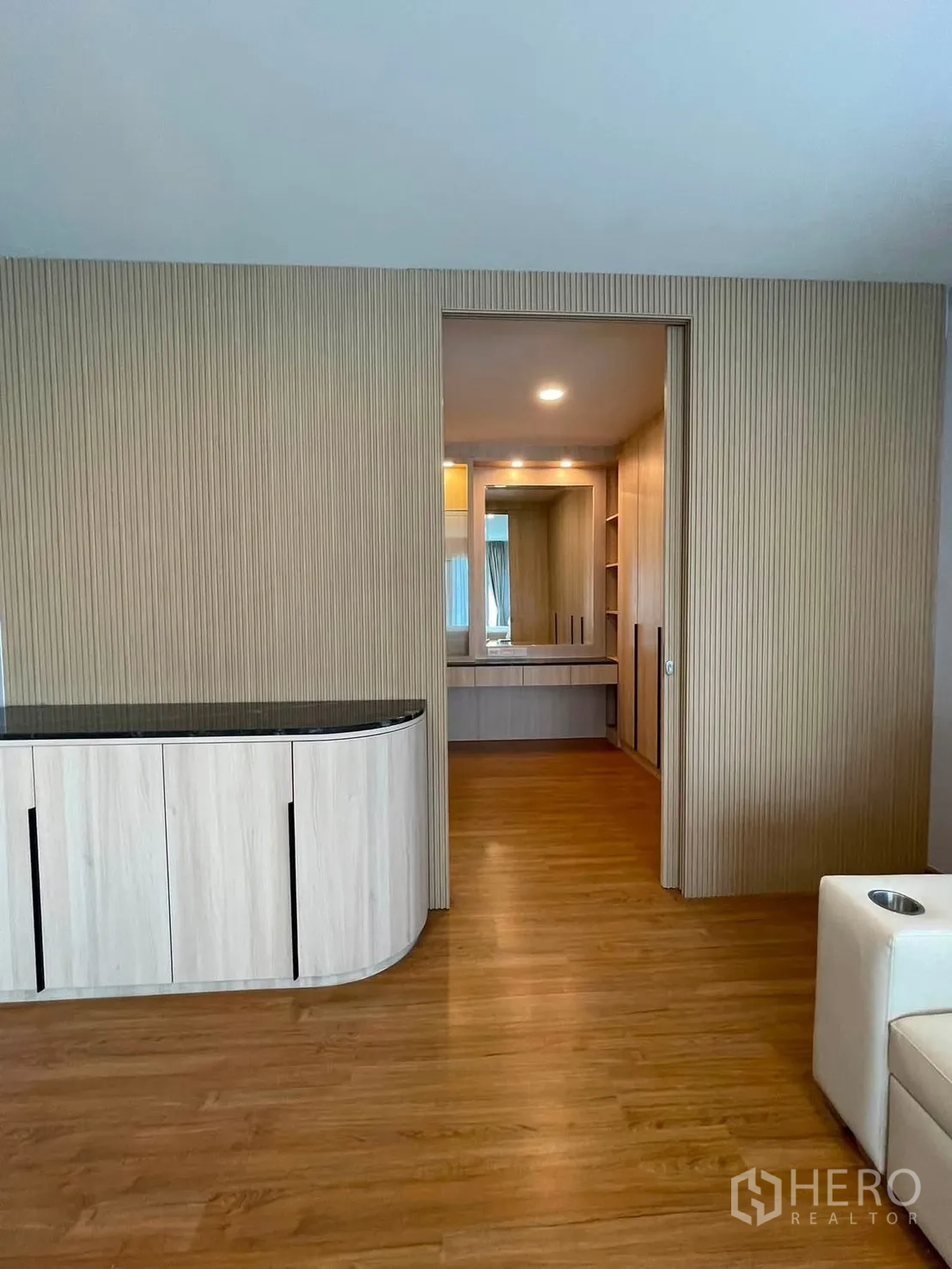 Detached House for rent in Bang Phli, Samut Prakan - Entrance to a walk-in closet with a curved built-in cabinet and wood wall panels.