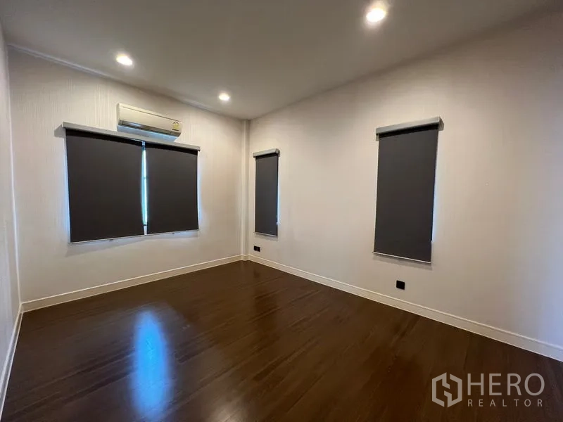Detached House for rent or sale in Bang Kapi, Bangkok - Empty room with wood floors, recessed lighting and blackout roller blinds.