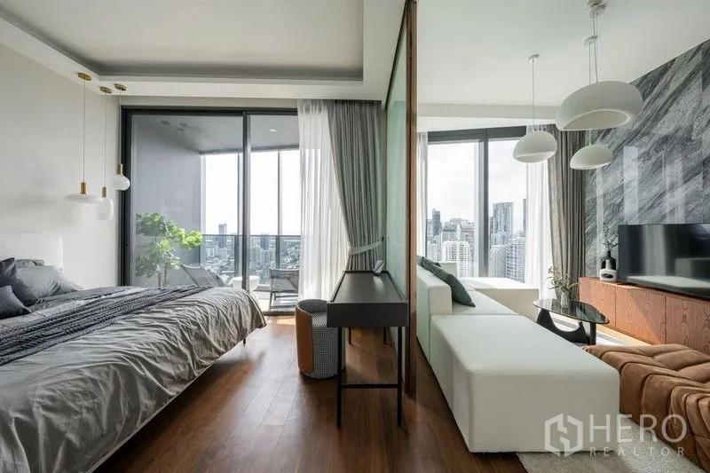 Condominium for rent in Khlong Toei, Bangkok - Open-plan layout with frosted glass divider between bedroom and living room facing the balcony.