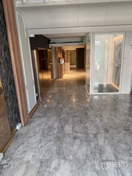 店屋 出租 - 一层室内，抛光大理石地面、玻璃入口与木质柜体。