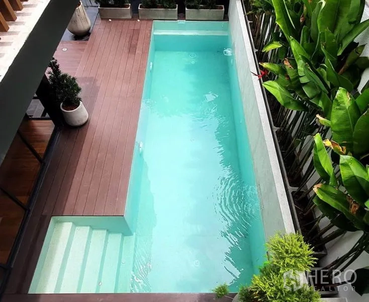 带办公室的家 出租或出售在Khlong Toei, Bangkok - 俯视窄型碧蓝泳池，带入水台阶与木平台，周边绿植环绕。