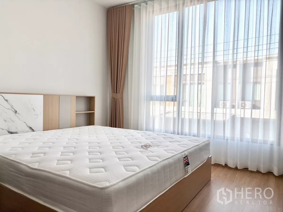 Townhouse for rent in Bang Phli, Samut Prakan - Sunlit bedroom with large window and new mattress.