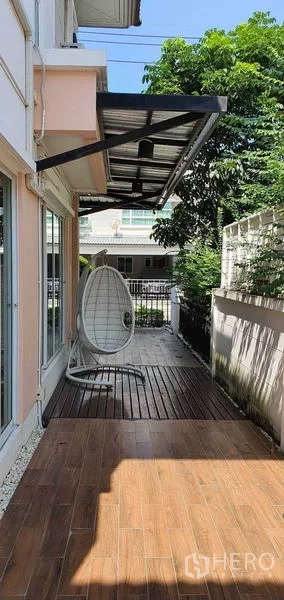 Detached House for sale in Khan Na Yao, Bangkok - Wood-deck walkway along the house with sliding glass doors and garden wall.