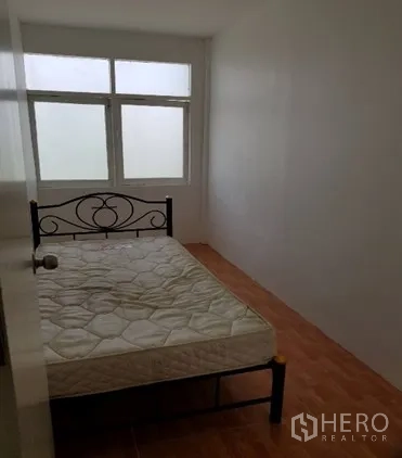 Shophouse for rent in Watthana, Bangkok - Narrow bedroom with bed and tiled floor.