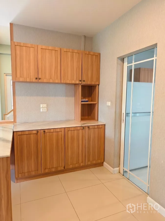 Detached House for rent in Bang Kapi, Bangkok - Pantry with wood cabinets and sliding door to kitchen.