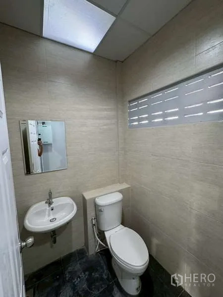 Warehouse for rent in Bang Phli, Samut Prakan - Second restroom with toilet and wall-mounted sink under a skylight