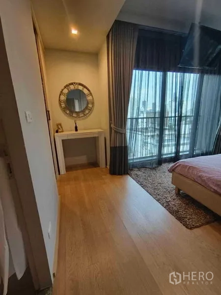 公寓 出租在Bangkok - 卧室一角设梳妆台与大窗，推拉门连接城市景观阳台。