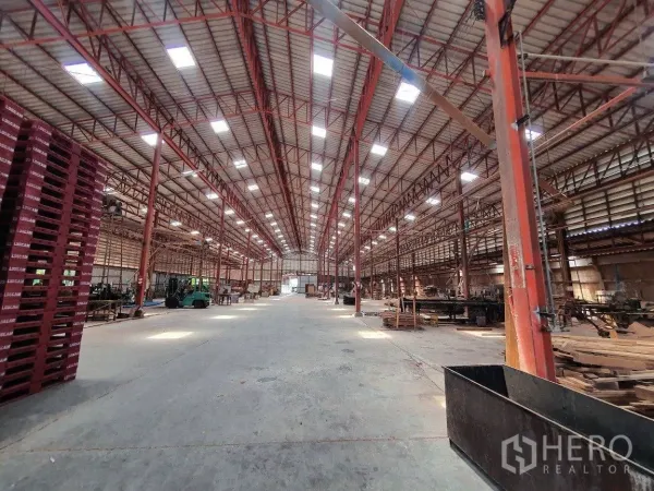 货栈 出租在Lam Luk Ka, Pathum Thani - 仓库中央通道宽敞，天窗采光，红色钢柱与叉车