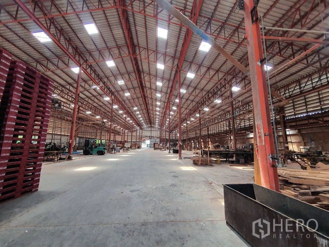 货栈 出租在Lam Luk Ka, Pathum Thani - 仓库中央通道宽敞，天窗采光，红色钢柱与叉车