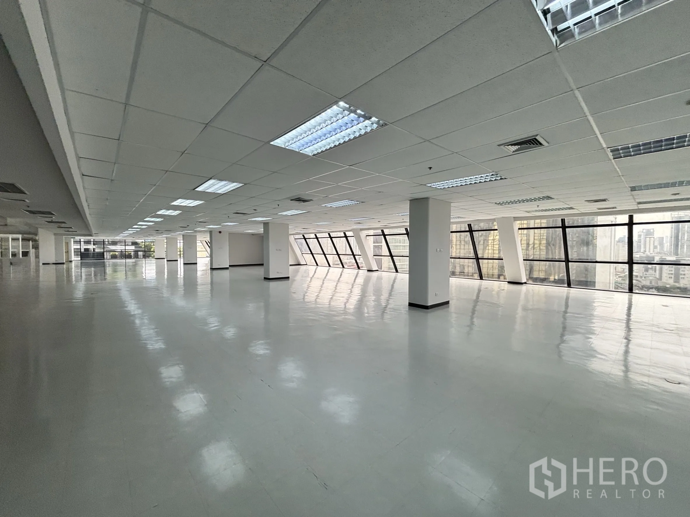 ออฟฟิศ for rent in Ratchathewi, Bangkok - ออฟฟิศทั้งชั้นขนาดใหญ่ มีกระจกต่อเนื่อง เสาโครงสร้าง และทิวทัศน์เมือง.
