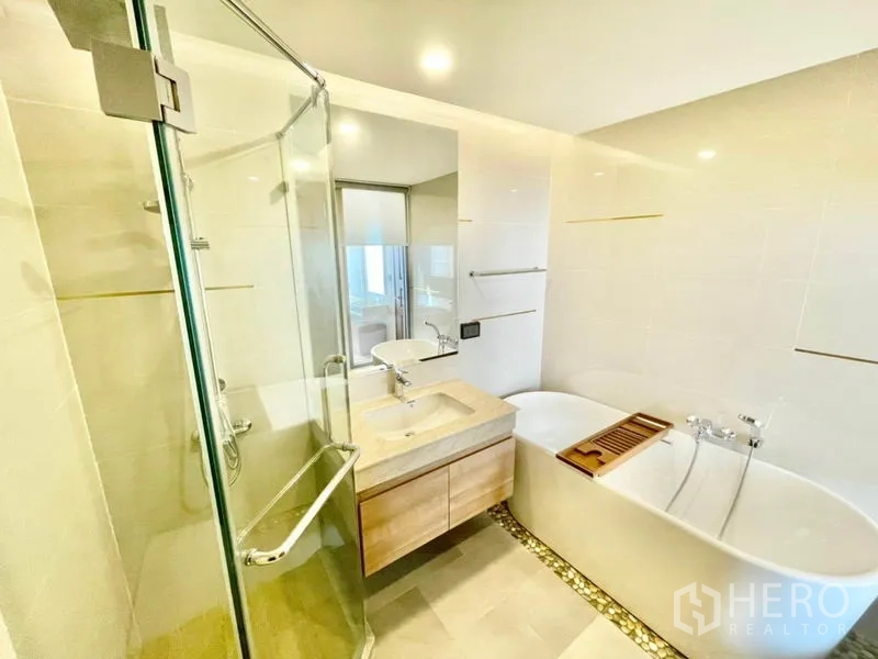 公寓 出售在Huai Khwang, Bangkok - 浴室设玻璃淋浴间、浴缸与单盆台面。