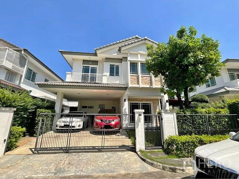 独立式住宅 出售在Prawet, Bangkok - 房屋正立面，两层独栋别墅，带大门与有顶车位。