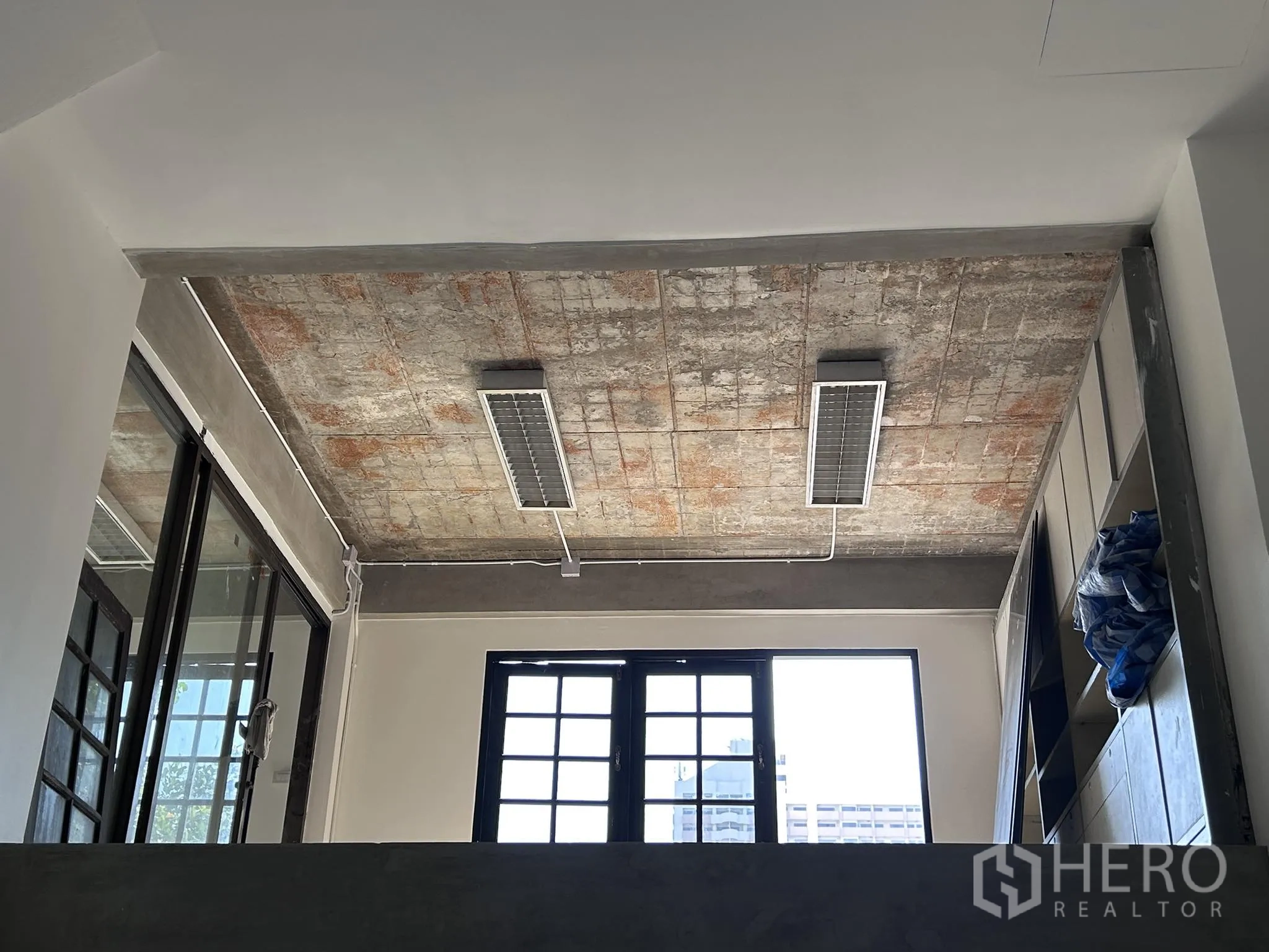 家庭办公室 for rent or sale in Watthana, Bangkok - 裸露混凝土天花细节，配荧光灯具。