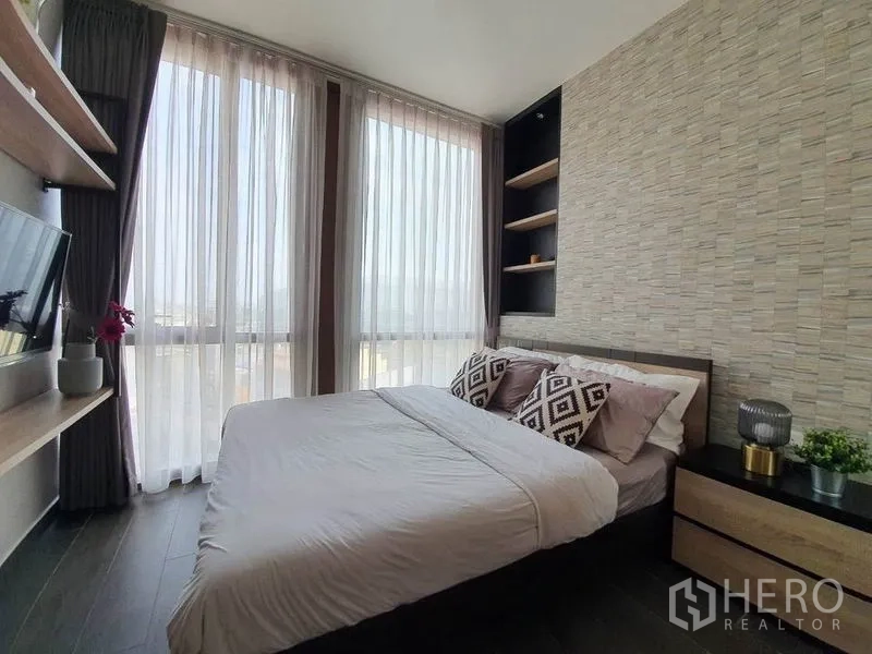 公寓 出租或出售在Watthana, Bangkok - 第二卧室配床、墙面电视、纱帘与纹理特色墙。