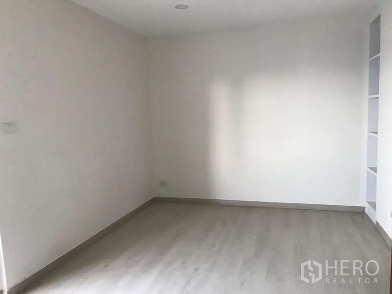 公寓 出售在Watthana, Bangkok - 明亮卧室，浅色地板，墙面内嵌置物架。