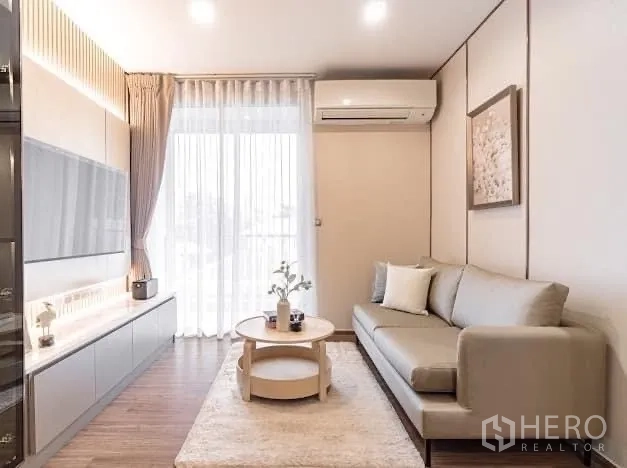 คอนโด ให้เช่าในWatthana, Bangkok - ห้องนั่งเล่นสว่าง มีโซฟา ผนังทีวี และม่านบานระเบียง