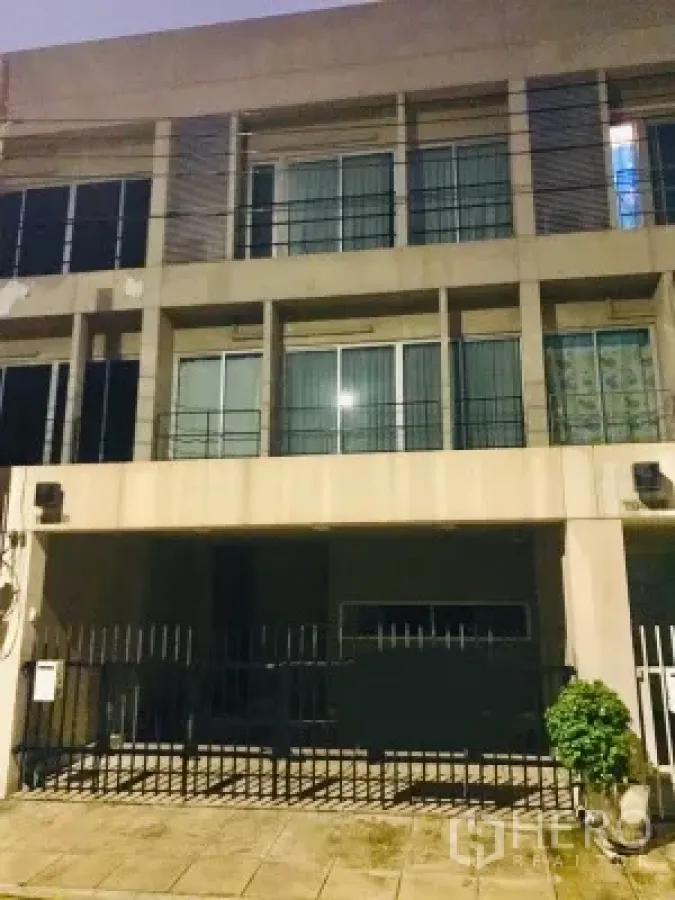 Townhouse for rent in Suan Luang, Bangkok - Multi-storey townhouse facade at Noble Cube Suan Luang with gated carport at night