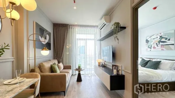 公寓 出租在Watthana, Bangkok - 客厅设壁挂电视与空调，卧室门旁落地窗采光充足。