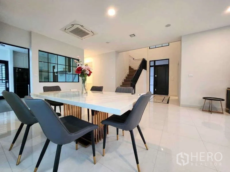 Detached House for rent in Saphan Sung, Bangkok - Contemporary dining area with marble-top table and six chairs next to the staircase.