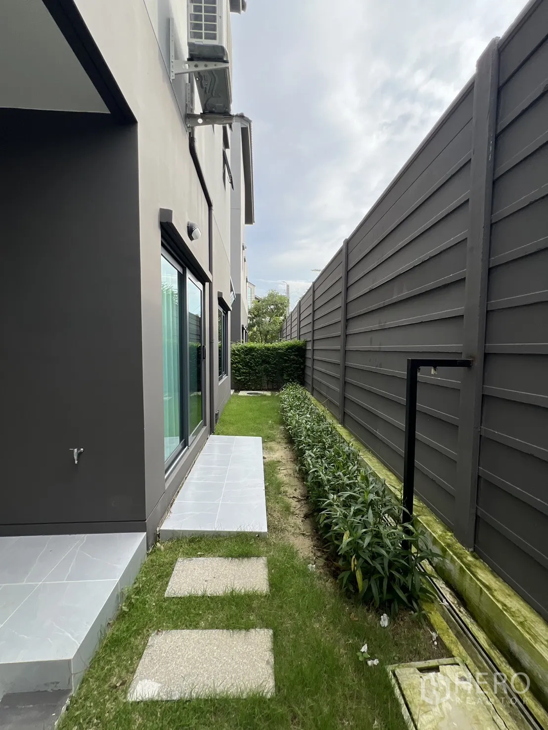 独立式住宅 出租在Prawet, Bangkok - 侧庭花园，踏步石与私密围墙旁的绿植。