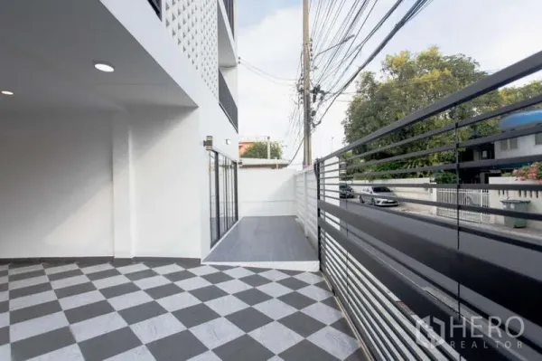 带办公室的家 出售在Huai Khwang, Bangkok - 前院与车道，黑色金属栅栏与图案地砖。