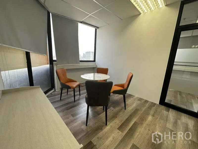 Office Space for rent or sale in Din Daeng, Bangkok - Small meeting nook with round marble table and four chairs by a window.