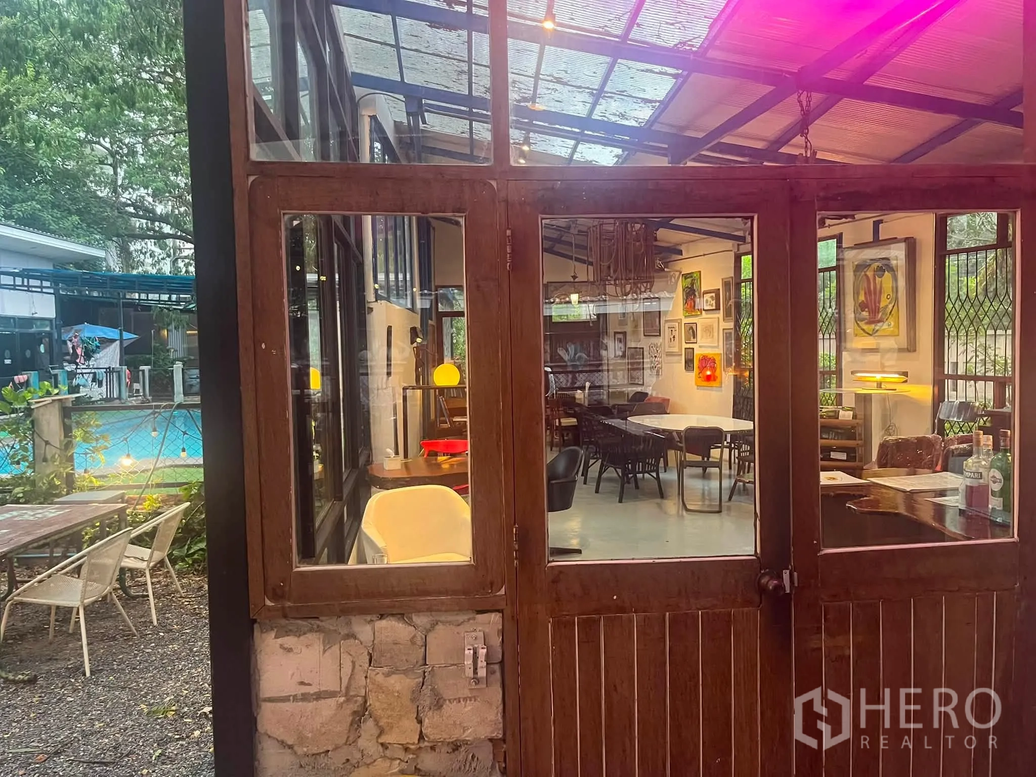 Retail Space for rent in Watthana, Bangkok - Rustic wooden double doors opening into a light-filled retail space with varied seating.