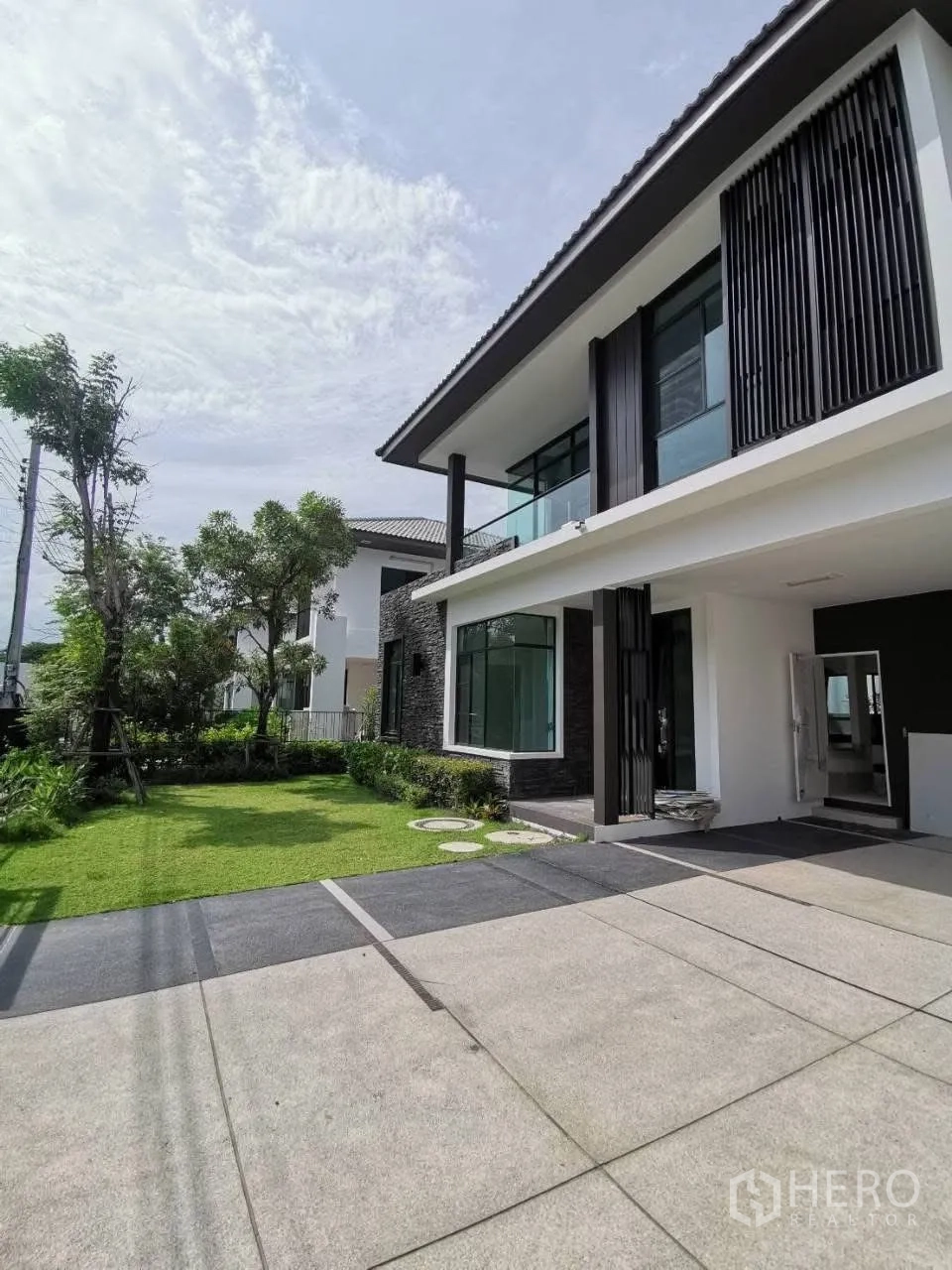 独栋房屋 for rent in Bang Phli, Samut Prakan - 房屋正面带宽阔车道、草坪与当代两层建筑设计。