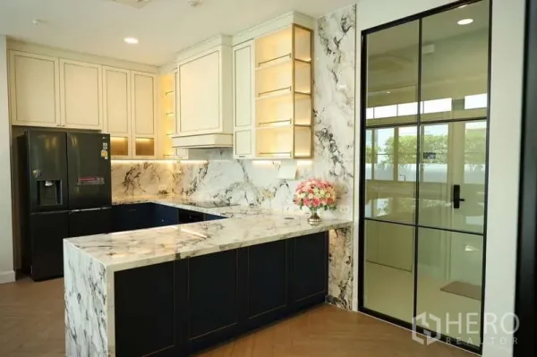 Detached House for rent or sale in Saphan Sung, Bangkok - Modern marble kitchen with L-shaped counter, black fridge and glass door.